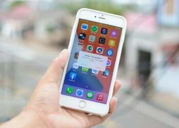 An image of a person holding a smartphone while the screen shows the action to permanently delete their Facebook account.