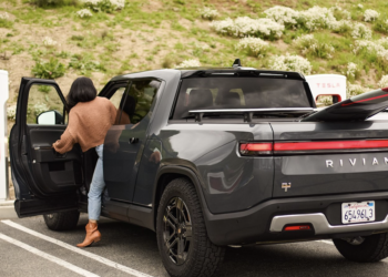 Rivian R1T charging at a Tesla Supercharger station